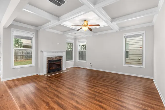 a view of empty room with fireplace and wooden floor