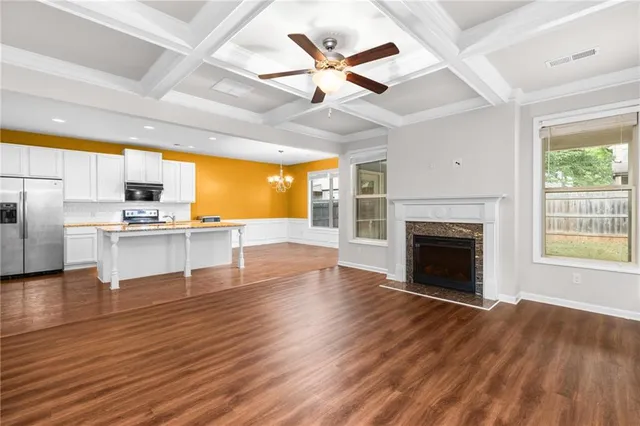 a view of open kitchen with granite countertop stainless steel appliances and wooden floor