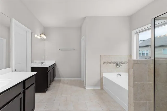 a spacious bathroom with a bathtub sink and mirror