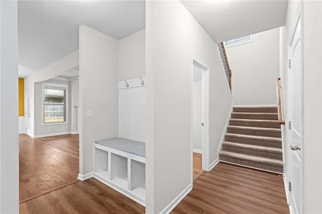 a view of a hallway with wooden floor and staircase