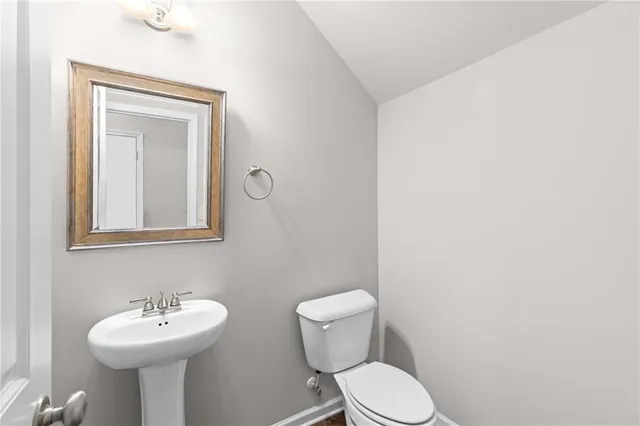a bathroom with a sink mirror and toilet
