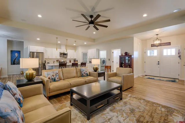 a kitchen with kitchen island granite countertop wooden floors and white cabinets