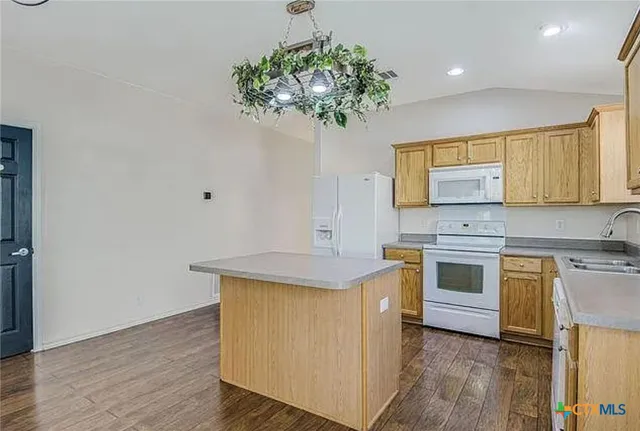 a kitchen with kitchen island a sink stainless steel appliances and cabinets
