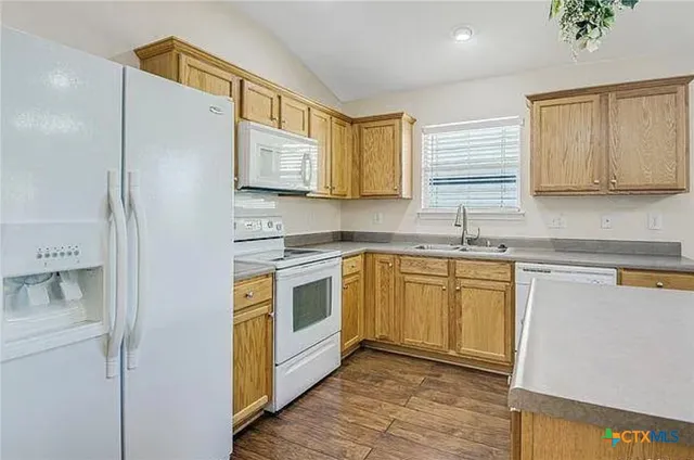 a kitchen with stainless steel appliances granite countertop a sink a stove a refrigerator a microwave and cabinets