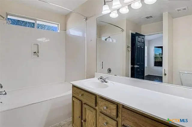 a bathroom with a sink vanity granite and a mirror