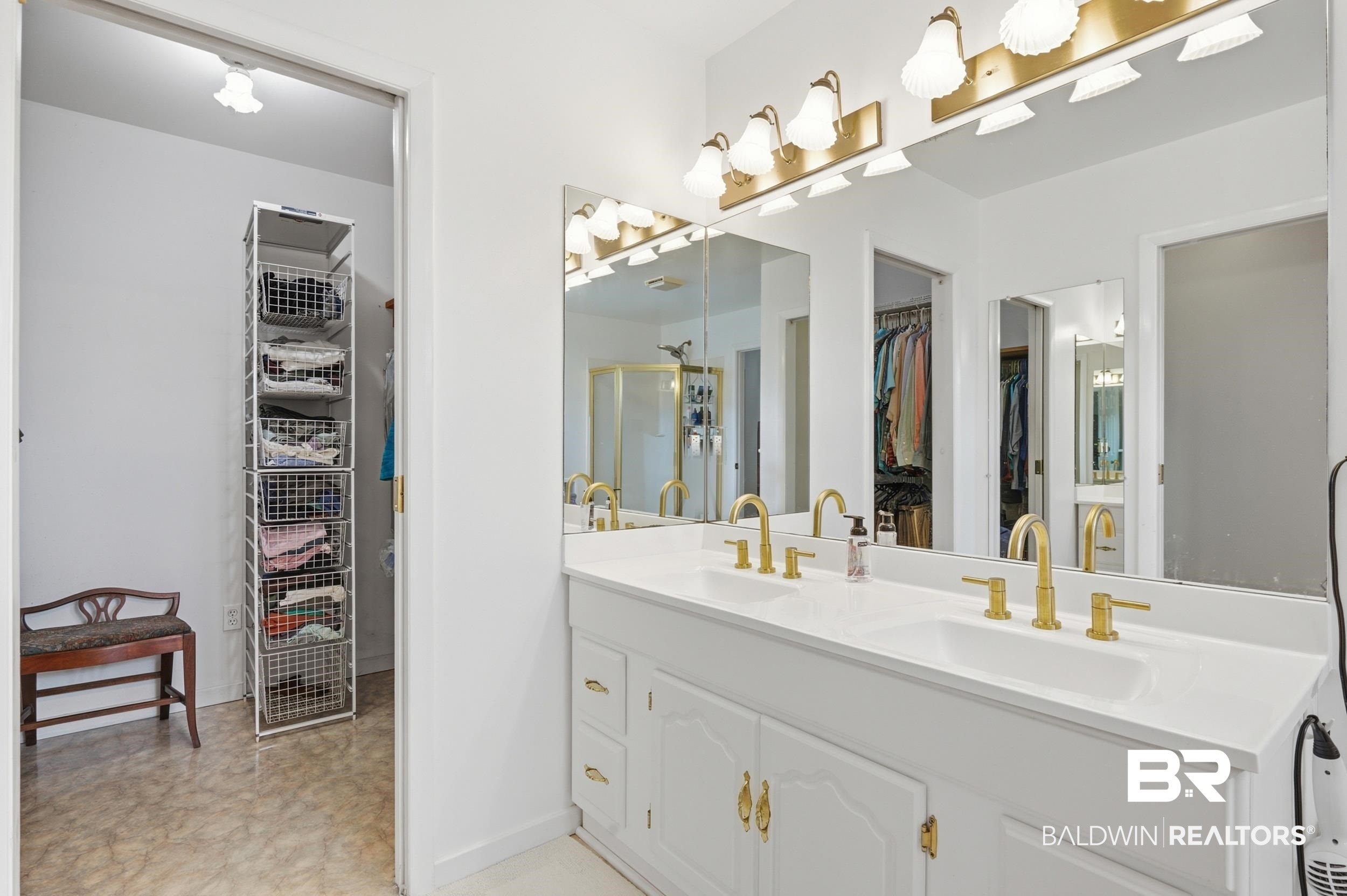 15855 Calvin Richerson Road Bay Minette, AL 36507 - Photo 59 of 83 Double vanity with white cabinetry, gold-toned hardware, dual sinks, and matching gold-toned fixtures