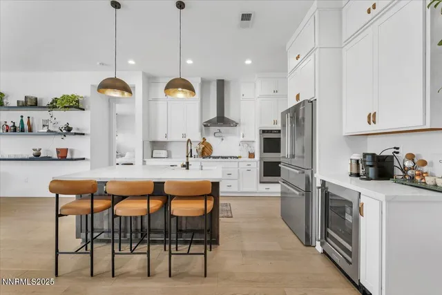 a kitchen with stainless steel appliances kitchen island granite countertop a table chairs and a refrigerator