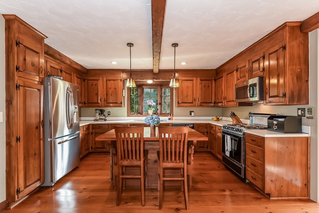 243 Newbury Road Rowley, MA 01969 - Photo 3 of 23 a kitchen with stainless steel appliances granite countertop a refrigerator a stove top oven a sink dishwasher and wooden cabinets