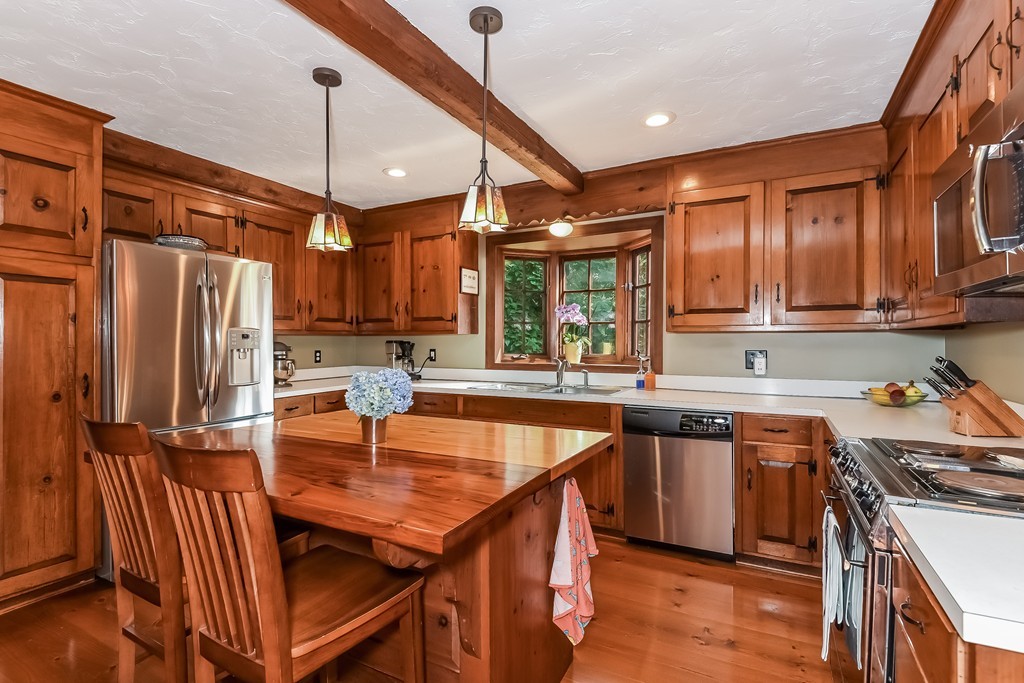 243 Newbury Road Rowley, MA 01969 - Photo 5 of 23 a kitchen with stainless steel appliances granite countertop a sink a stove and chairs