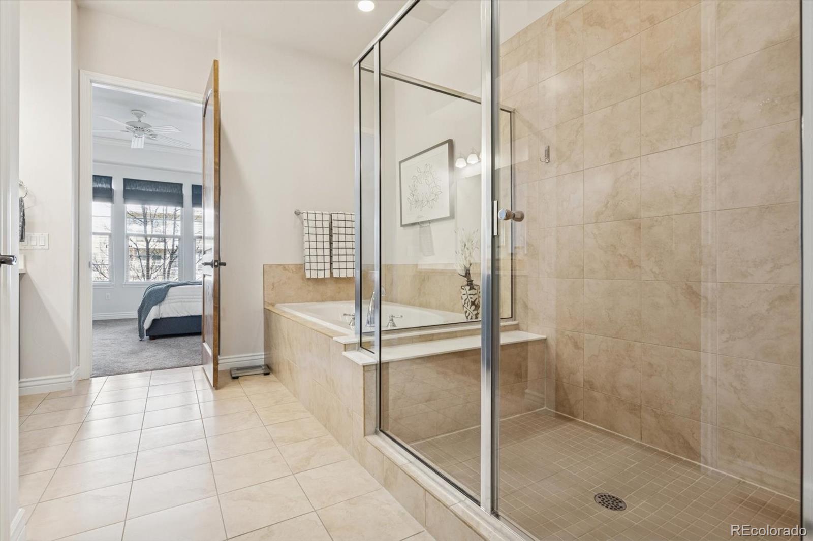10130 Inverness Main Street Englewood, CO 80112 - Photo 24 of 44 a bathroom with a glass shower door and a glass door