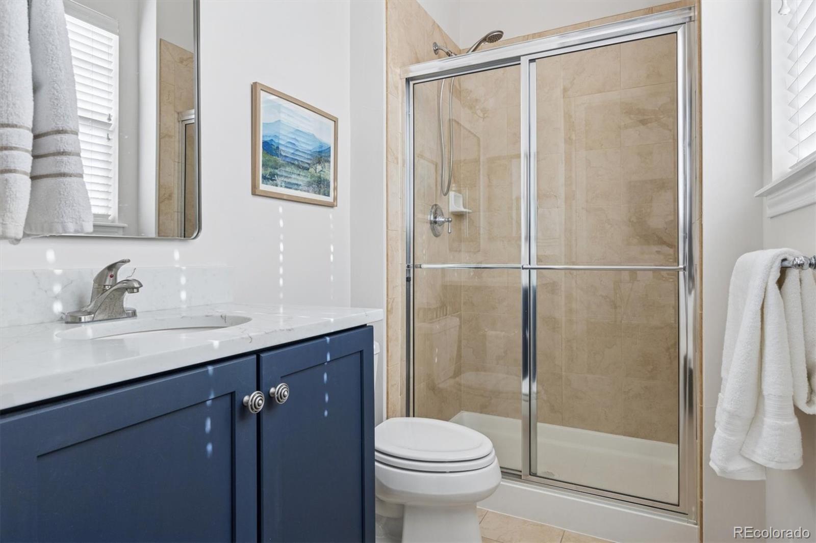 10130 Inverness Main Street Englewood, CO 80112 - Photo 27 of 44 a bathroom with a shower sink vanity mirror and toilet