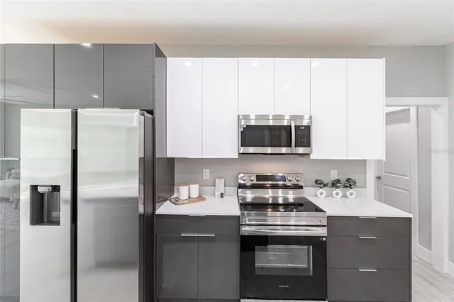 a kitchen with stainless steel appliances a refrigerator stove and microwave