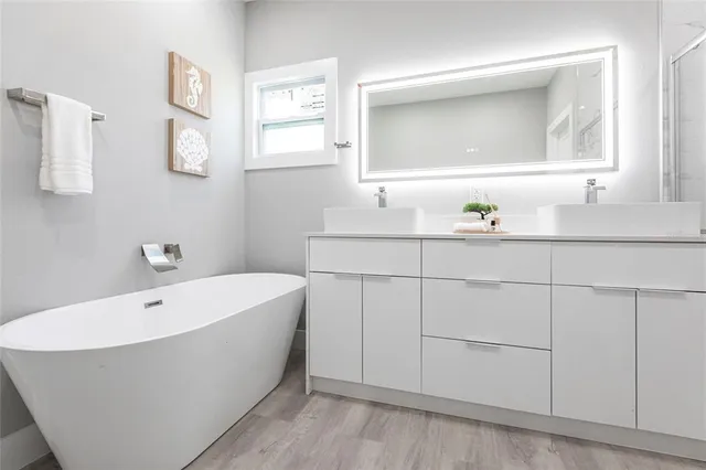 a bathroom with a bathtub a sink and mirror