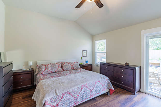 213 Chandler Crossing Trail Round Rock, TX 78665 - Photo 16 of 34 Bedroom featuring vaulted ceiling, access to exterior, dark wood finished floors, and ceiling fan