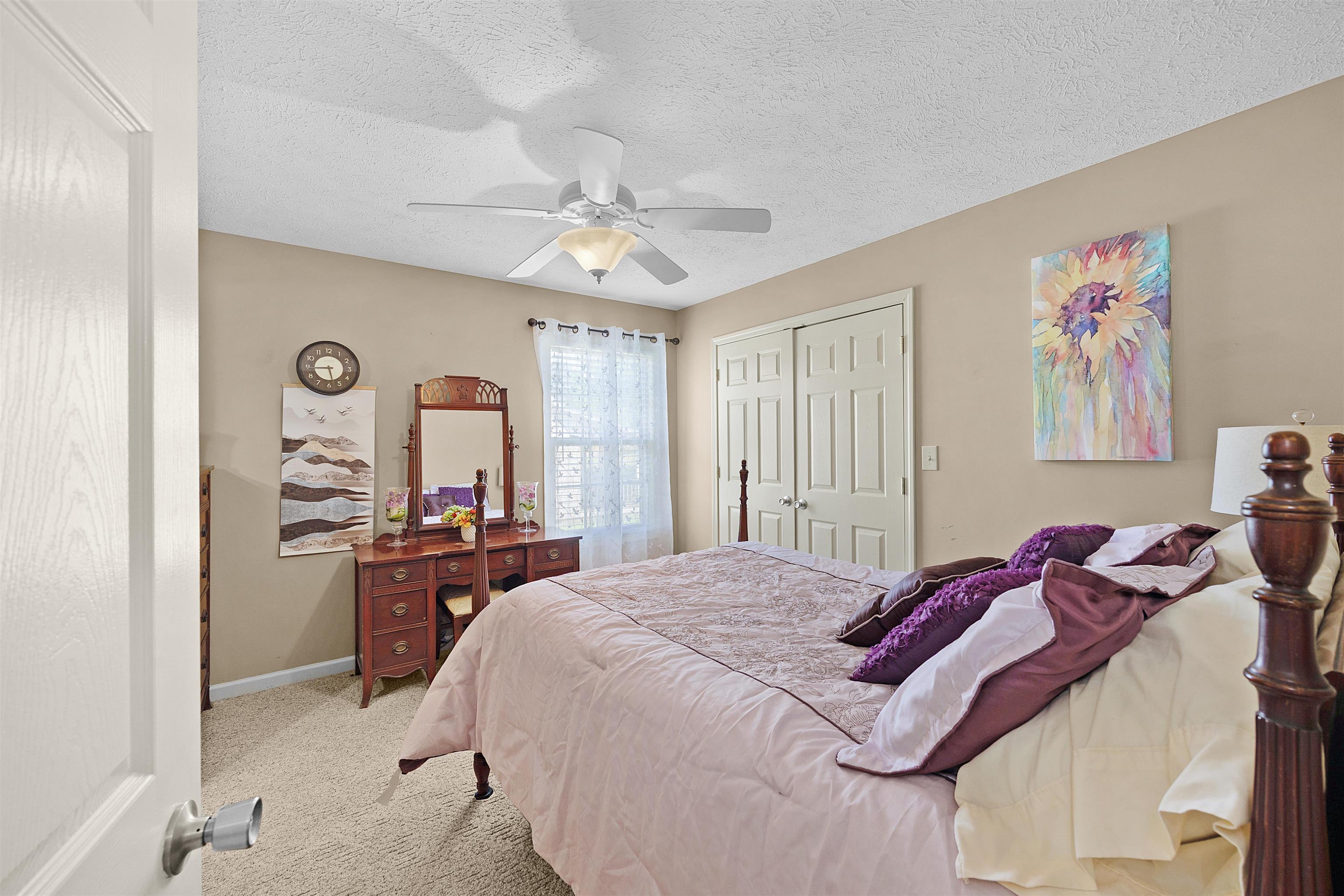 165 Ping Hl Cove Counce, TN 38326 - Photo 11 of 19 Bedroom with a ceiling fan, a textured ceiling, baseboards, a closet, and carpet