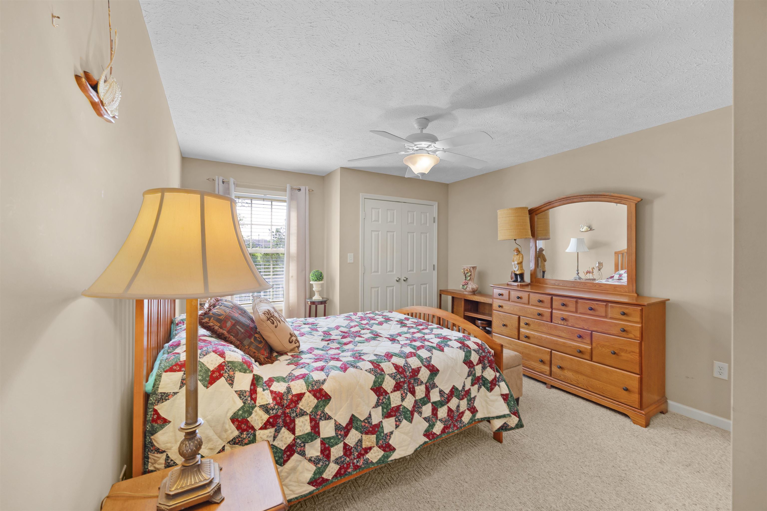165 Ping Hl Cove Counce, TN 38326 - Photo 16 of 19 Carpeted bedroom with a ceiling fan, a textured ceiling, baseboards, and a closet