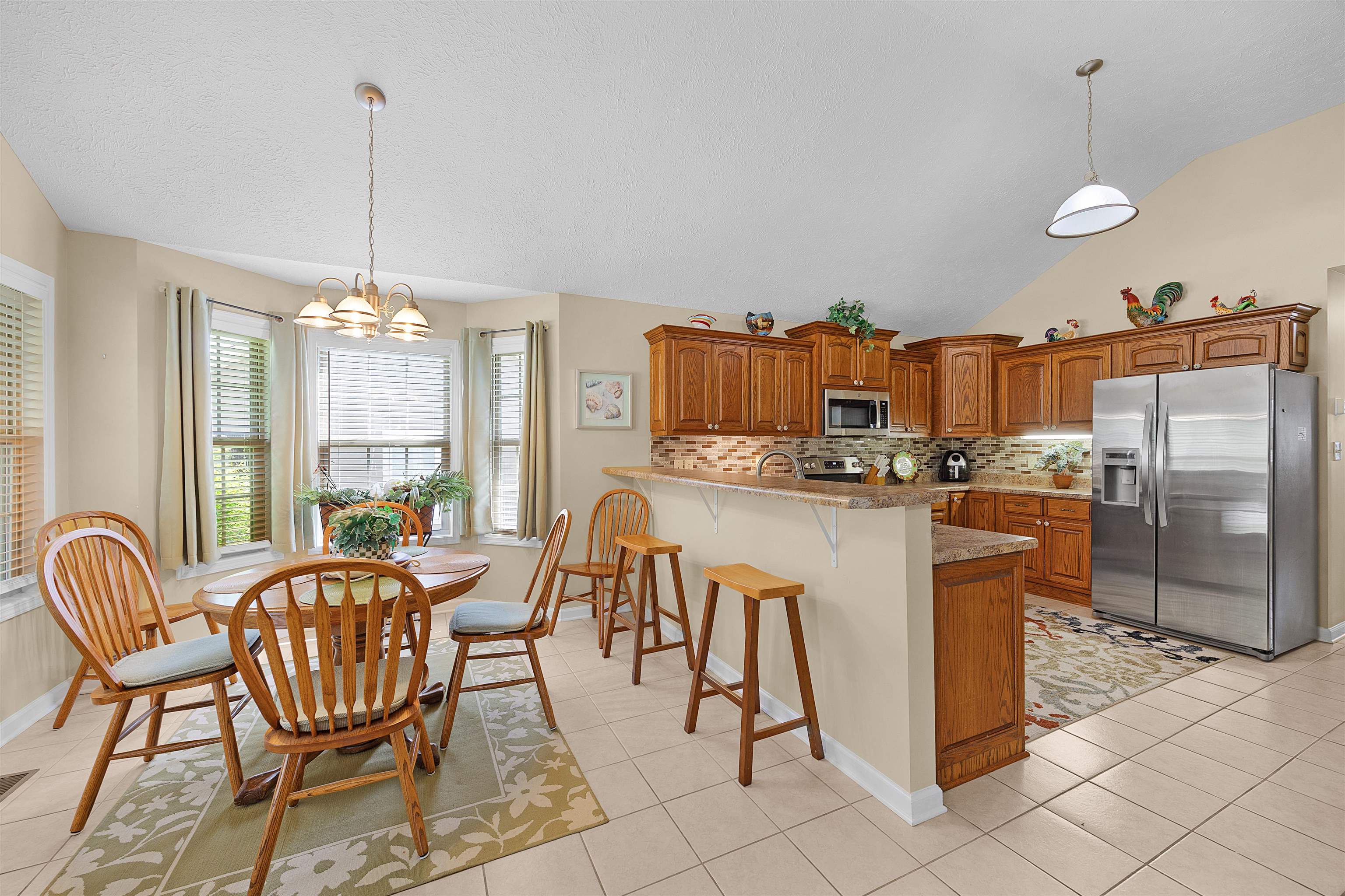 165 Ping Hl Cove Counce, TN 38326 - Photo 8 of 19 Kitchen featuring decorative backsplash, a kitchen breakfast bar, appliances with stainless steel finishes, brown cabinets, and a peninsula