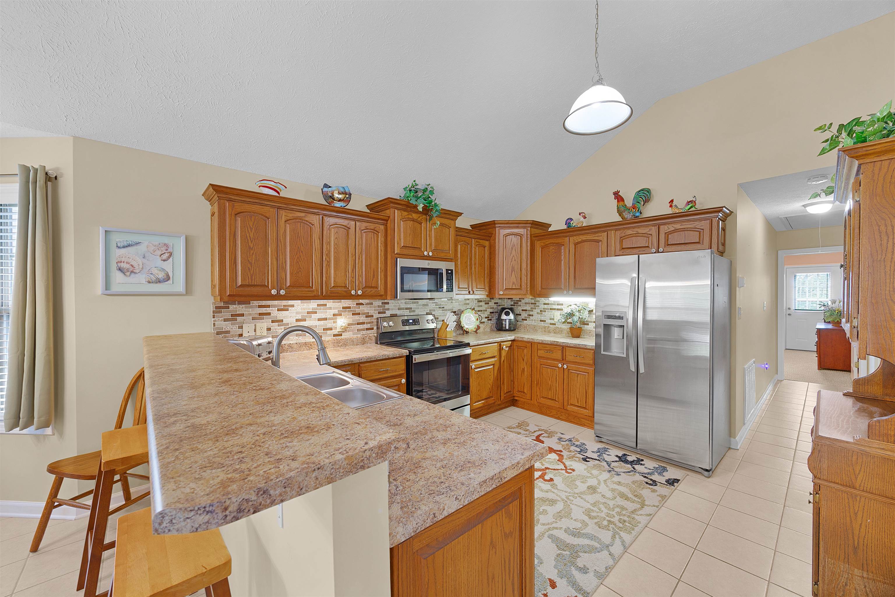 165 Ping Hl Cove Counce, TN 38326 - Photo 9 of 19 Kitchen featuring a peninsula, light countertops, a sink, light tile patterned floors, and stainless steel appliances