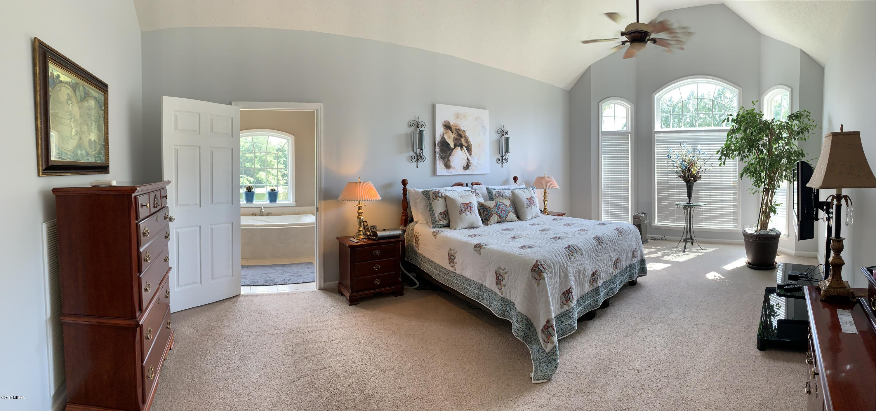 4540 Dixon Road Lizella, GA 31052 - Photo 22 of 59 a bed room with a bed and a chandelier