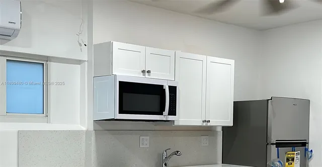a kitchen with stainless steel appliances white cabinets and a refrigerator