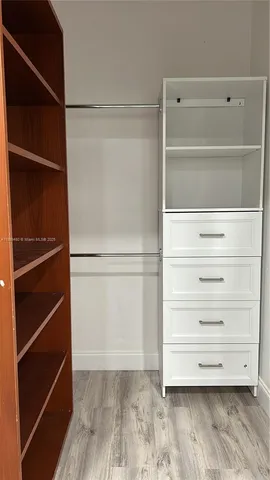 a view of walk in closet with empty racks