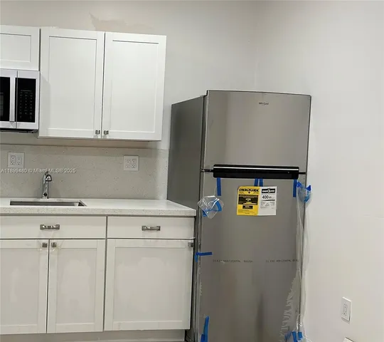 a kitchen with stainless steel appliances white cabinets and a sink