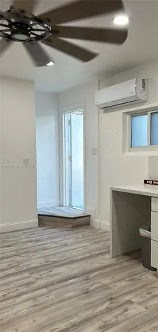 a view of an empty room with wooden floor and a cabinet