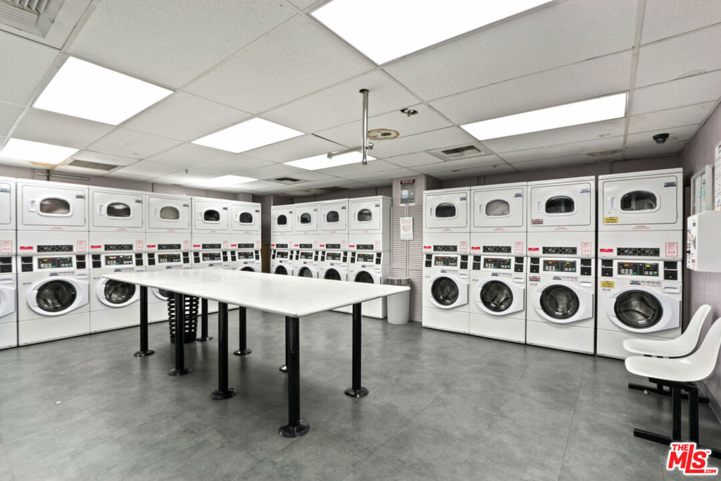 2160 Century Hill, Unit 605 Los Angeles, CA 90067 - Photo 18 of 18 a utility room with stainless steel appliances a white stove top oven a sink a washer and dryer next to a window