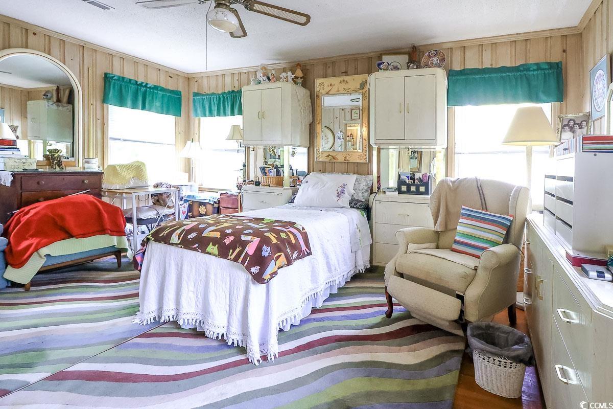 404 13th Avenue South Myrtle Beach, SC 29577 - Photo 11 of 38 Bedroom featuring wooden walls and a ceiling fan