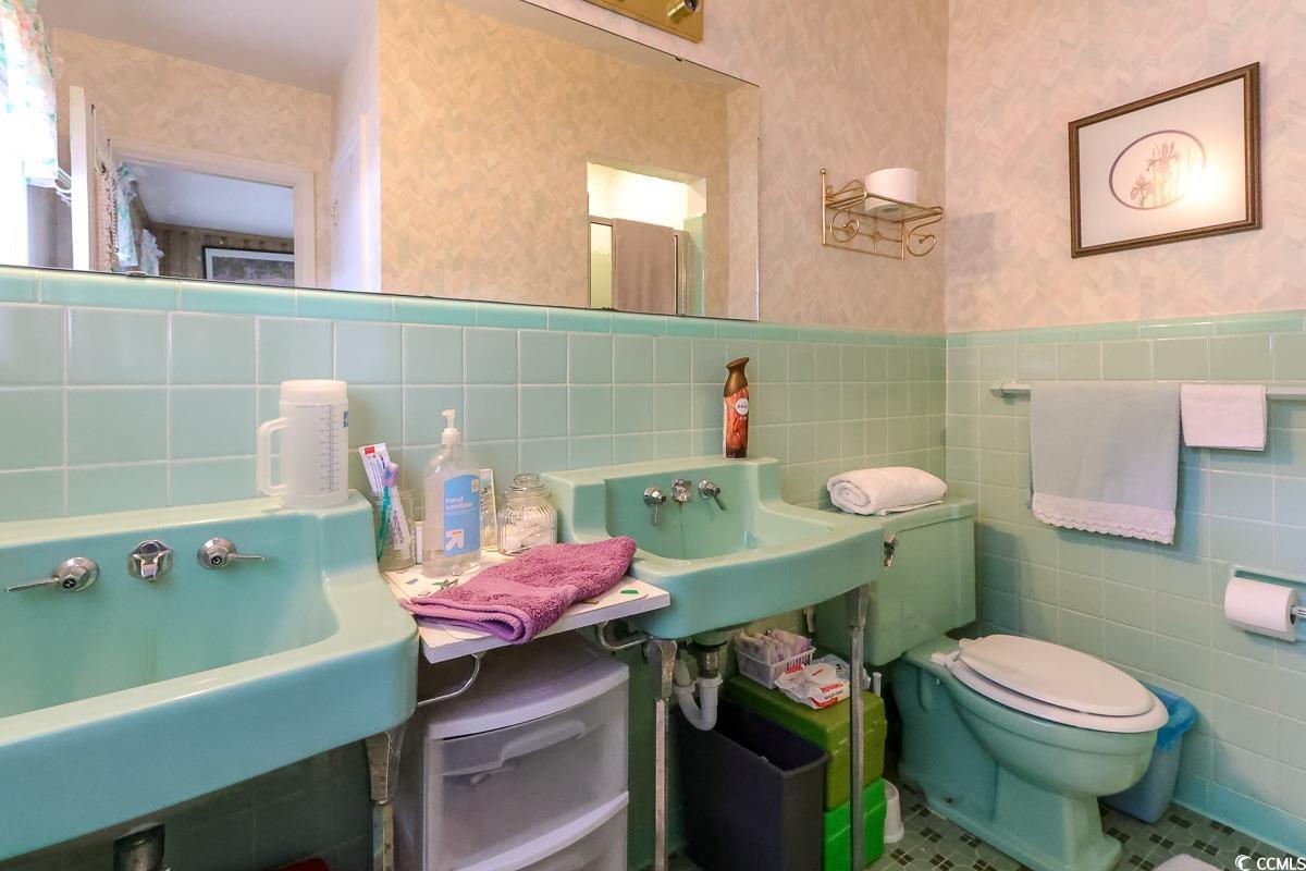 404 13th Avenue South Myrtle Beach, SC 29577 - Photo 17 of 38 Bathroom with wallpapered walls, tile walls, and a wainscoted wall