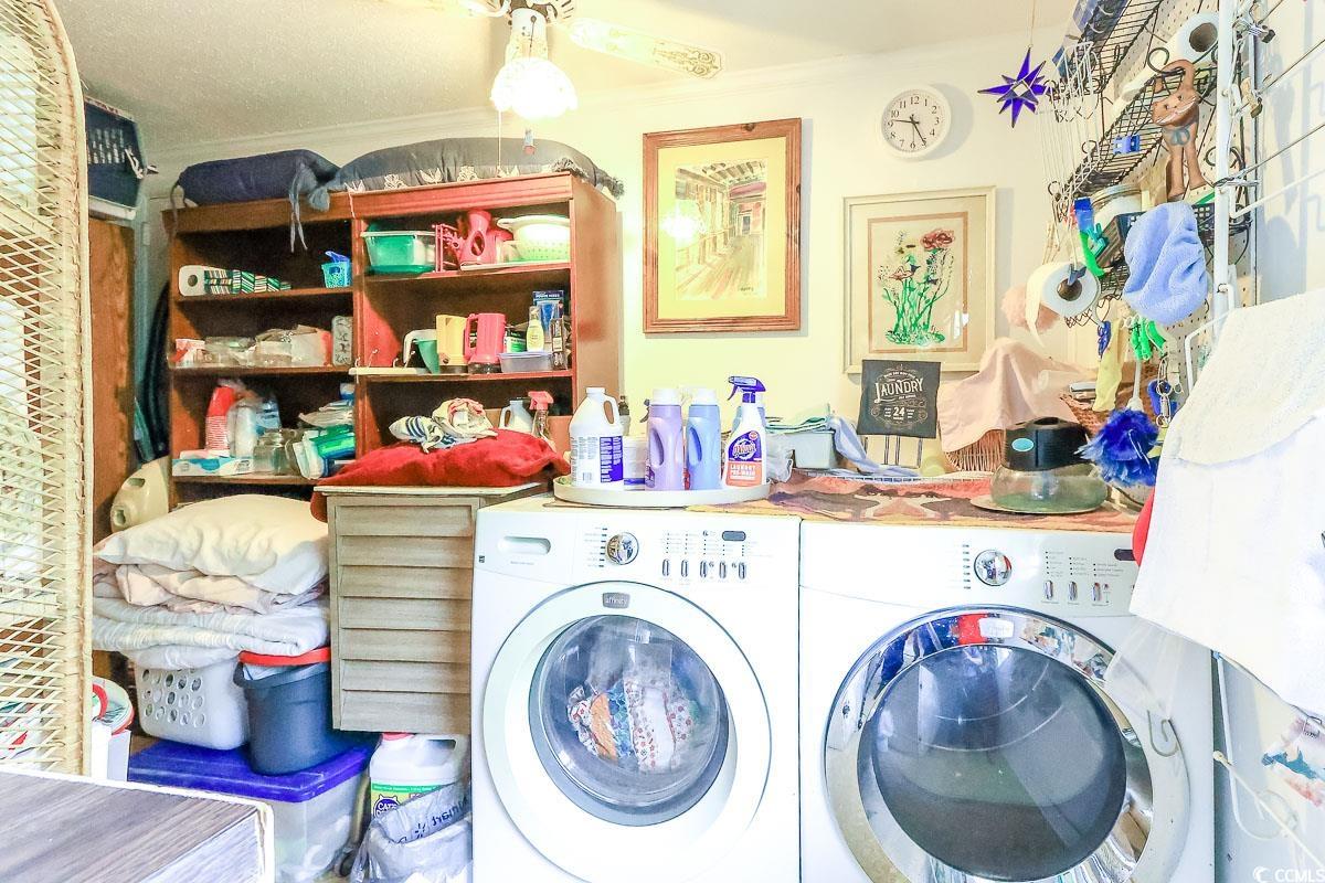 404 13th Avenue South Myrtle Beach, SC 29577 - Photo 19 of 38 Laundry room featuring washing machine and clothes dryer, ornamental molding, and a ceiling fan