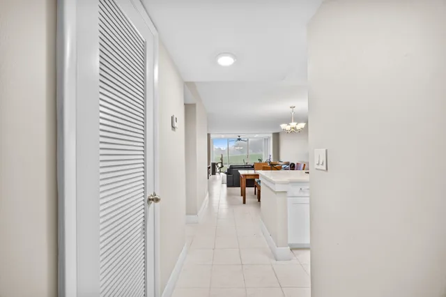 a view of a kitchen with kitchen island white cabinetry and stainless steel appliances
