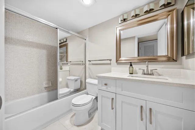 a bathroom with a sink a toilet a mirror and shower