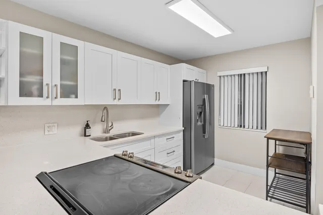 a kitchen with stainless steel appliances granite countertop a refrigerator and a stove top oven