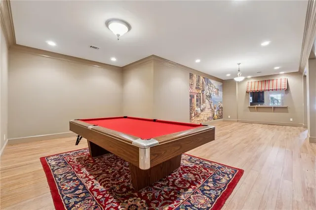 a room with pool table windows and wooden floor