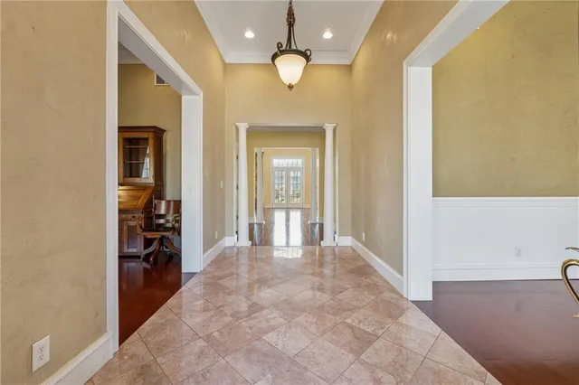 a view of a hallway with wooden floor and a bathroom