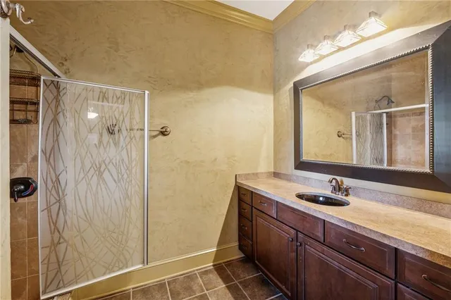 a bathroom with a granite countertop sink a mirror and a shower