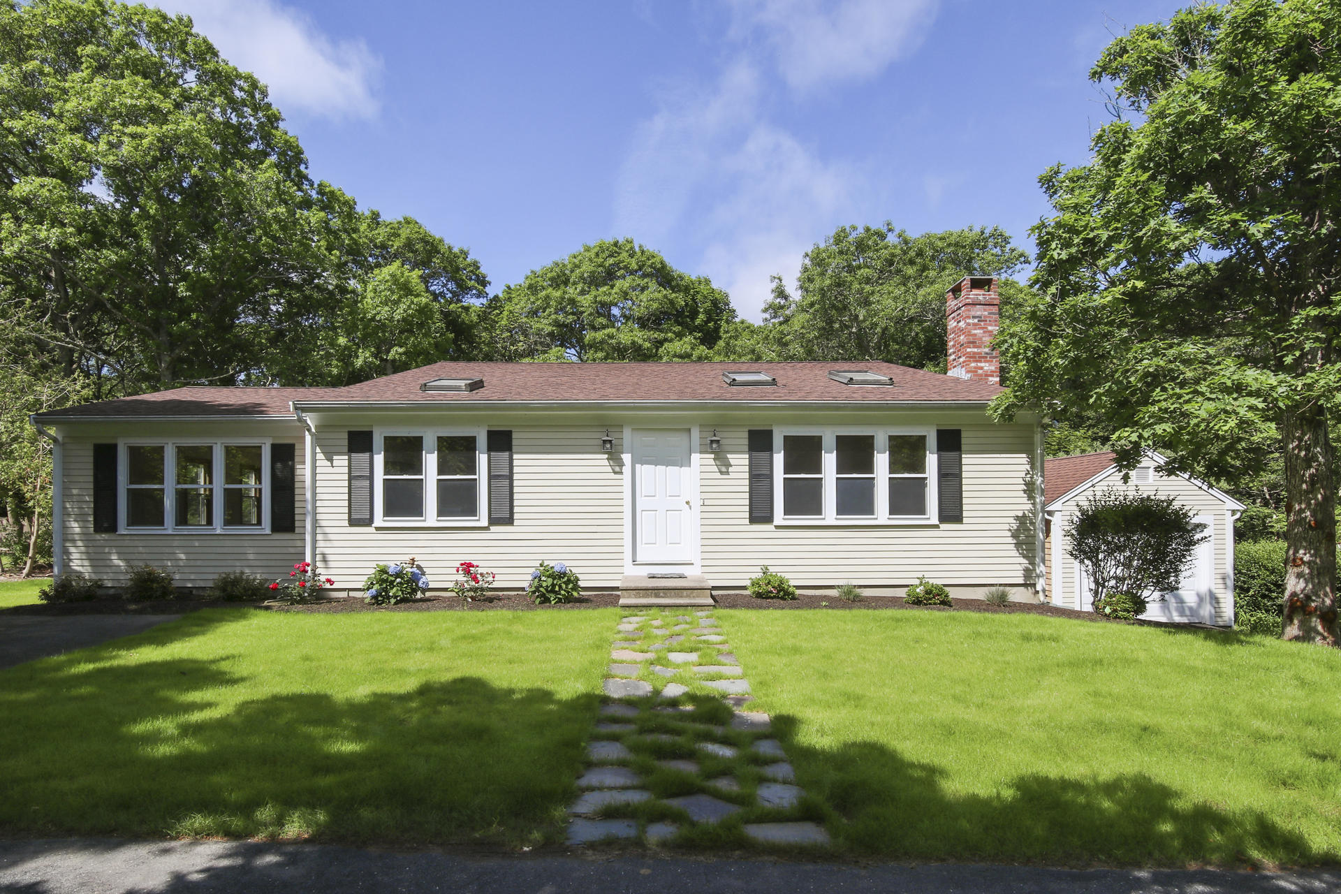 a front view of a house with a garden and plants