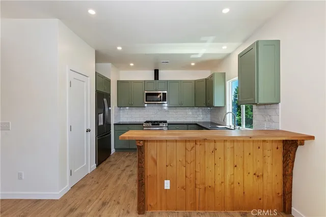 a large kitchen with stainless steel appliances granite countertop a stove and a refrigerator