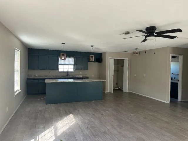 a kitchen with granite countertop a refrigerator and a sink