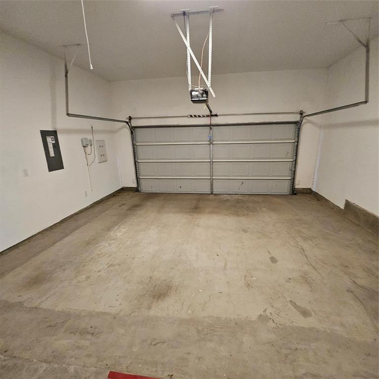 2309 Jack Rabbit Way Northlake, TX 76247 - Photo 28 of 28 Spacious garage with an overhead door system, concrete flooring, and white painted walls