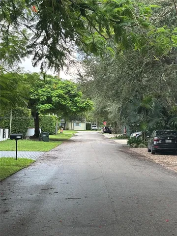 a view of a street with houses and trees
