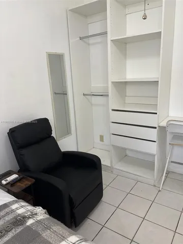 a living room with a bed and a cabinets