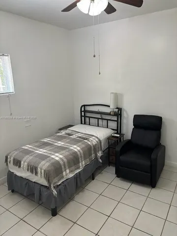 a bedroom with a bed chair and table