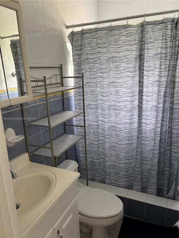 a bathroom with a toilet and a shower curtain