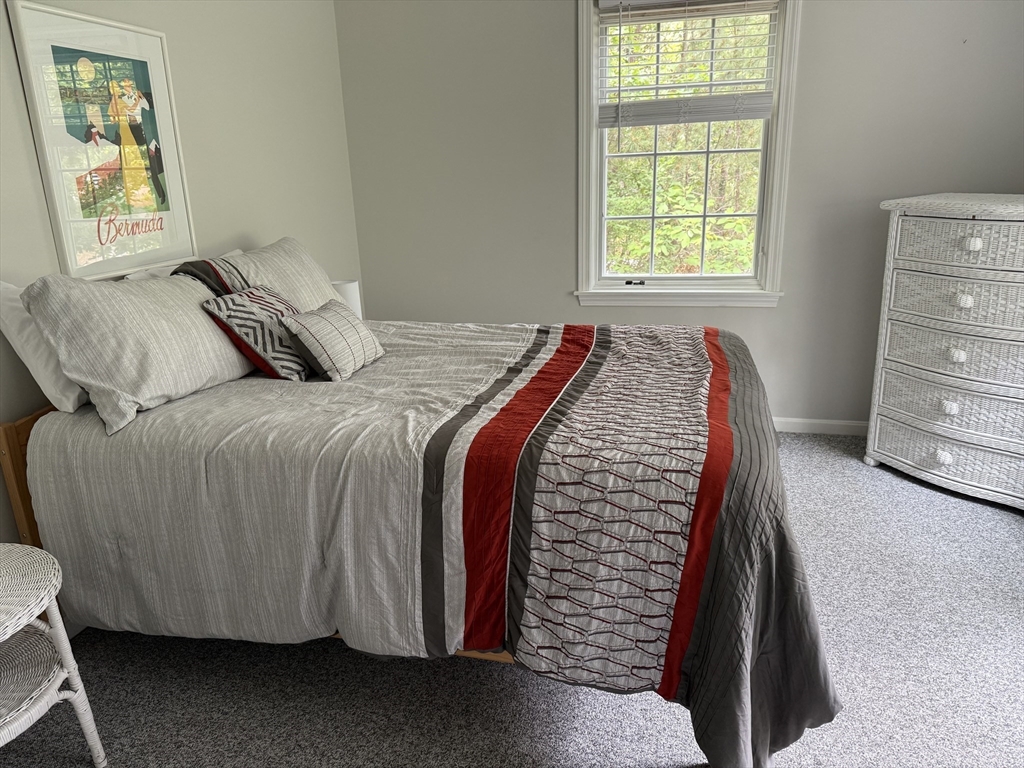 183 Monomoscoy Road Mashpee, MA 02649 - Photo 14 of 22 a bed sitting in a bedroom next to a window