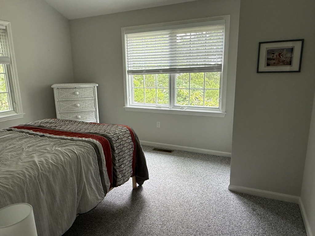 183 Monomoscoy Road Mashpee, MA 02649 - Photo 15 of 22 a bed sitting in a bedroom next to a window