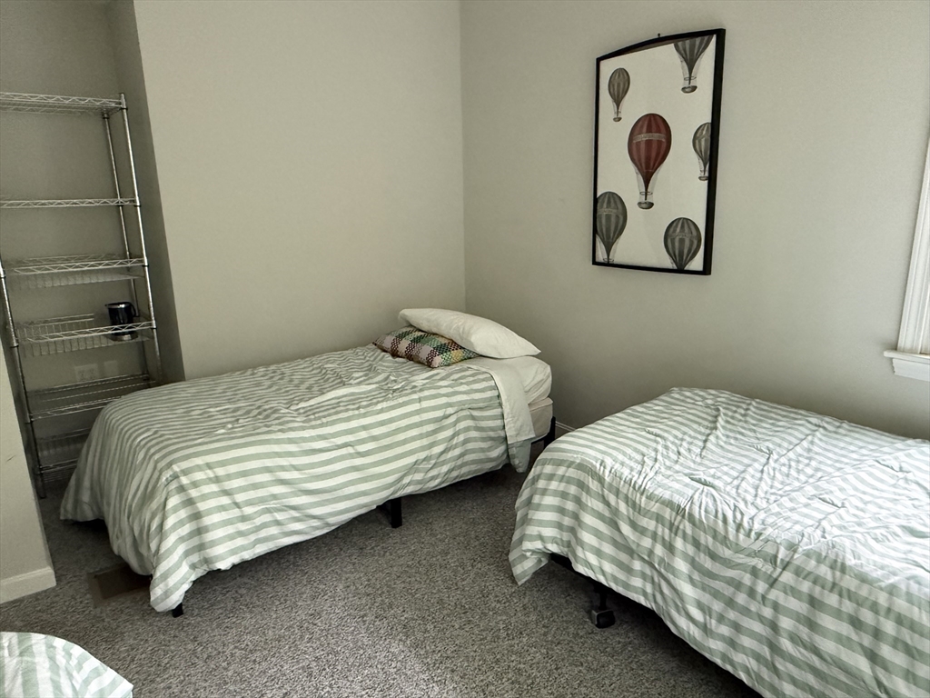 183 Monomoscoy Road Mashpee, MA 02649 - Photo 16 of 22 a bedroom with two bed and painting on the wall