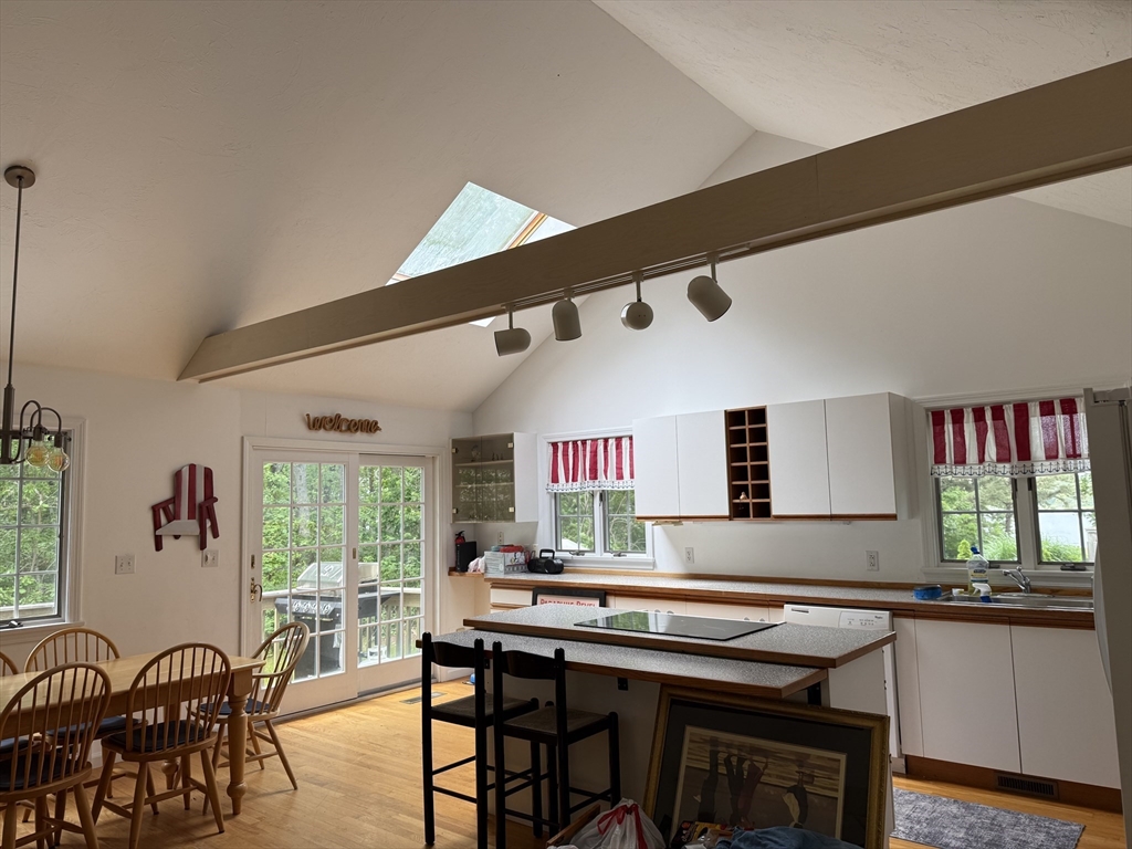 183 Monomoscoy Road Mashpee, MA 02649 - Photo 6 of 22 a kitchen with stainless steel appliances granite countertop a table chairs stove a sink dishwasher and cabinets with wooden floor