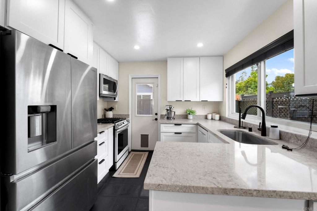 333 Sunflower Escondido, CA 92026 - Photo 4 of 36 a kitchen with stainless steel appliances granite countertop a refrigerator a sink a stove and a refrigerator with wooden floor